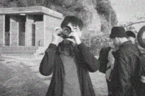 Yinghao Tang taking a photograph outdoors
