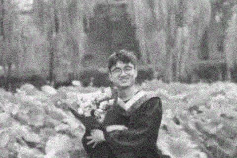 Yinghao Tang holding flowers on graduation day