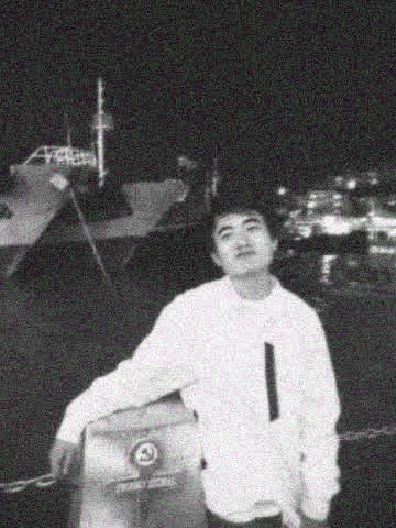 Yinghao Tang standing by a harbor at night